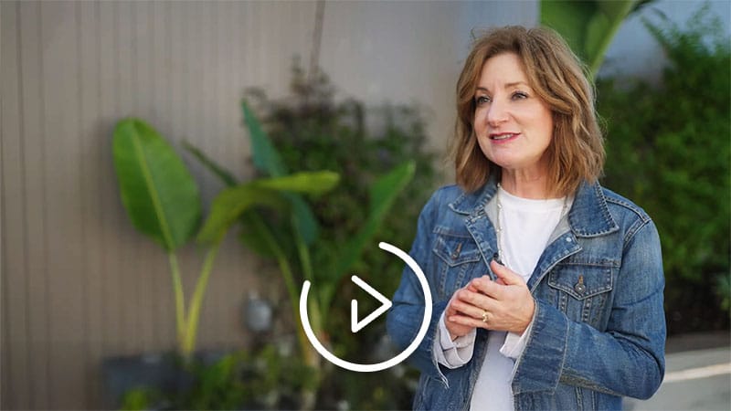 An elderly man with grey hair and a beaming smile is being attended to by a dentist wearing a mask and blue gloves. The dentist is examining the man's teeth with a dental mirror, indicating a routine dental check-up. The patient appears to be in a good mood and comfortable with the dental procedure.
